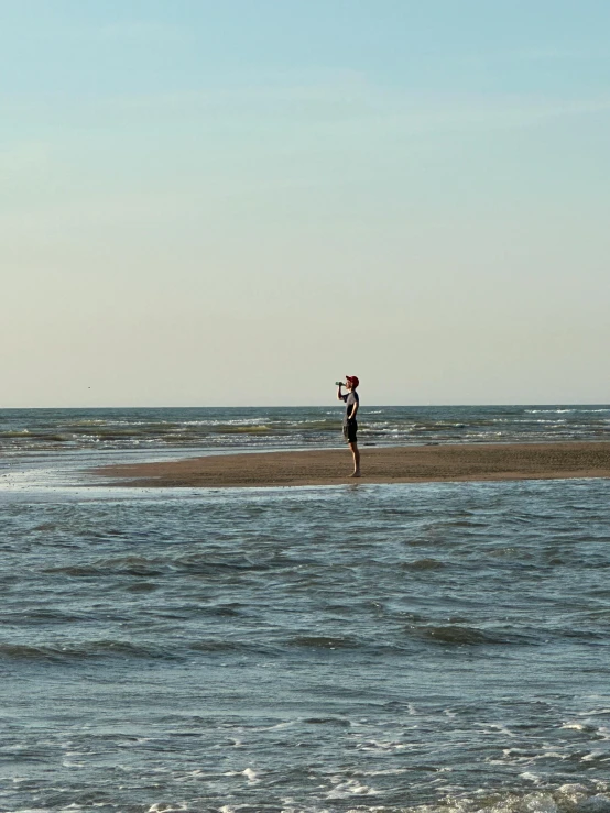 a person walking in the water on a beach