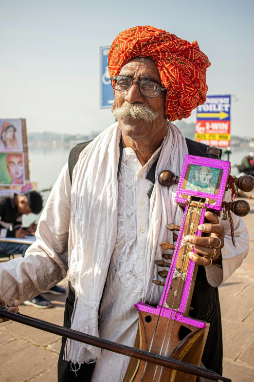 an old man plays a instrument near a beach