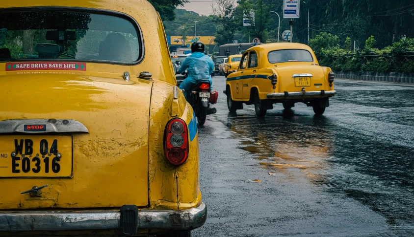 people riding on scooters in the rain