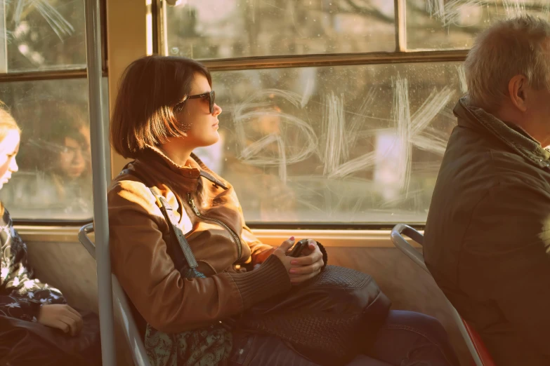 a woman is sitting in a train looking outside