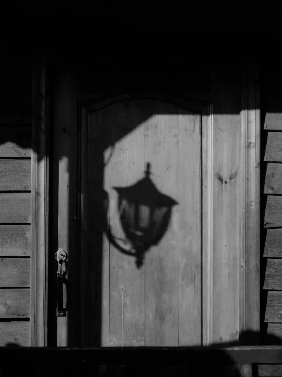 a shadow of a lamp on the side of a house