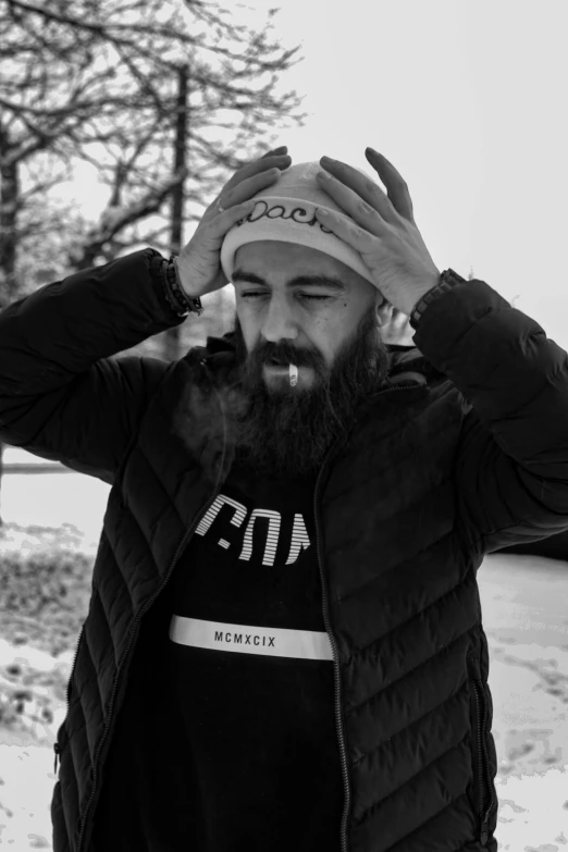 man with beard and black jacket in the snow