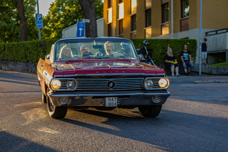 an old car driving down a street during the day