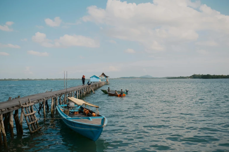 there is a boat floating on the water near a pier