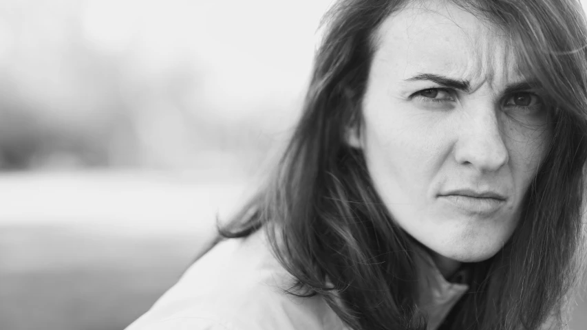 a woman with long hair is staring in the distance