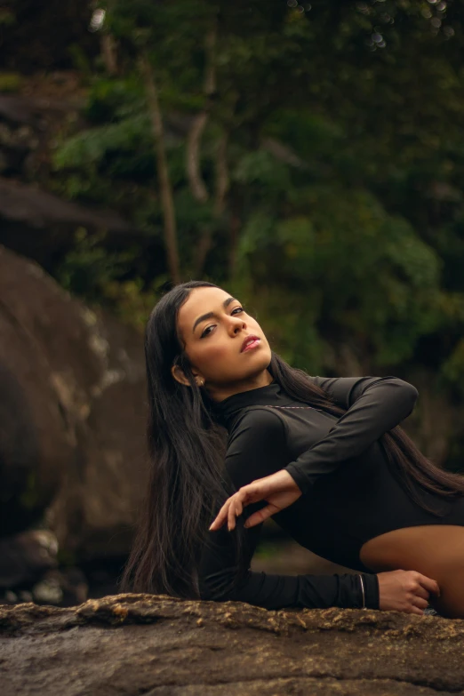 a woman laying down on top of a rock