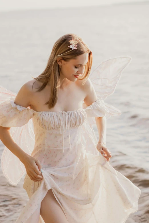 the woman is dressed in a fairy costume by the water