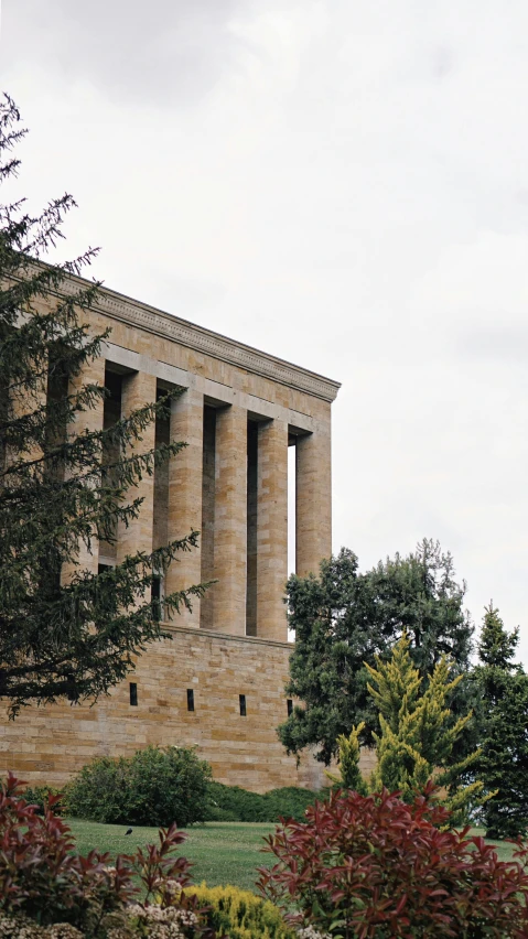 a tall brick building surrounded by trees and bushes