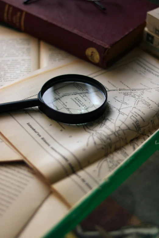 a magnifying glass on top of a pile of old books