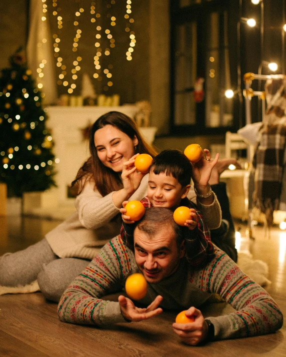 a family in a christmas party with oranges on the floor