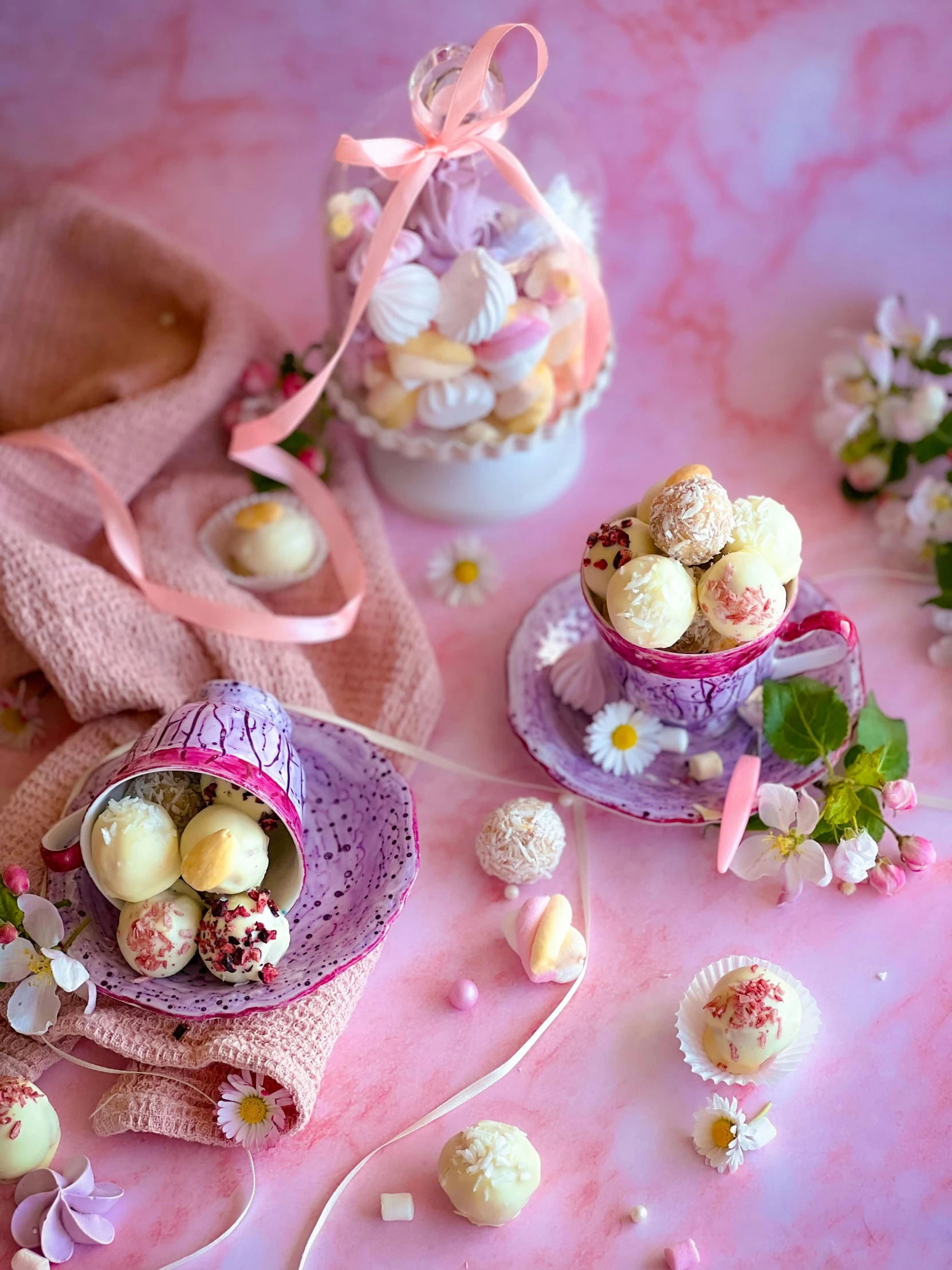 several decorated desserts in pastel pink on a marble surface