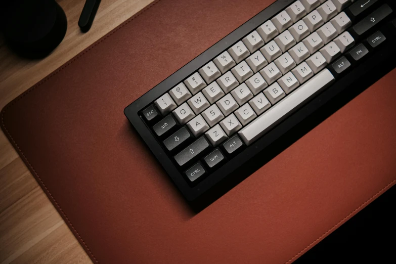 a computer keyboard and mouse on top of a red pad