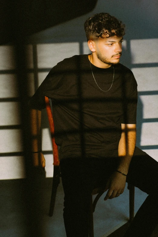 a man sits in an arm chair as his shadow is shining