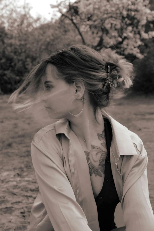 a woman with large earrings on is leaning against a wall