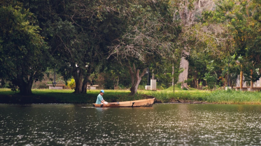 a man rows a small boat on the water