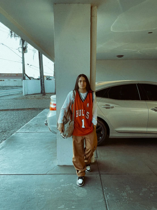 a woman walks on the sidewalk next to an orange police car