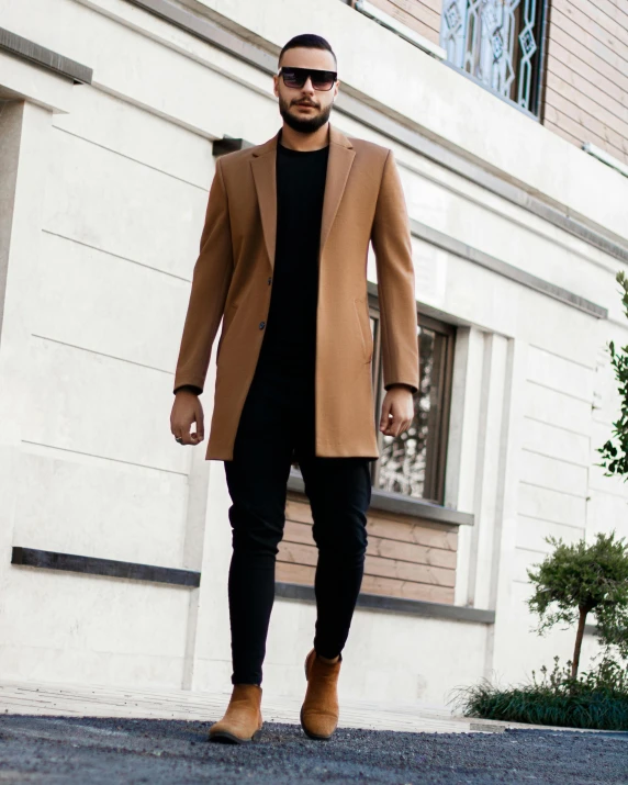 a man walking down the street wearing a brown coat