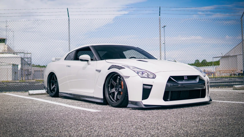 a white nissan sports car sits in a parking lot