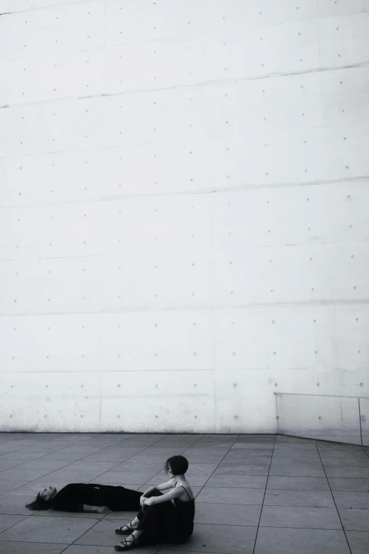 a person laying on the ground near a wall