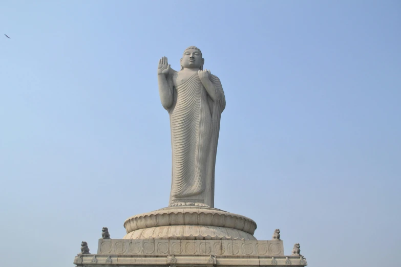large statue of a standing in front of a blue sky