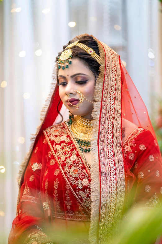 a bride in her wedding makeup looks down on the face