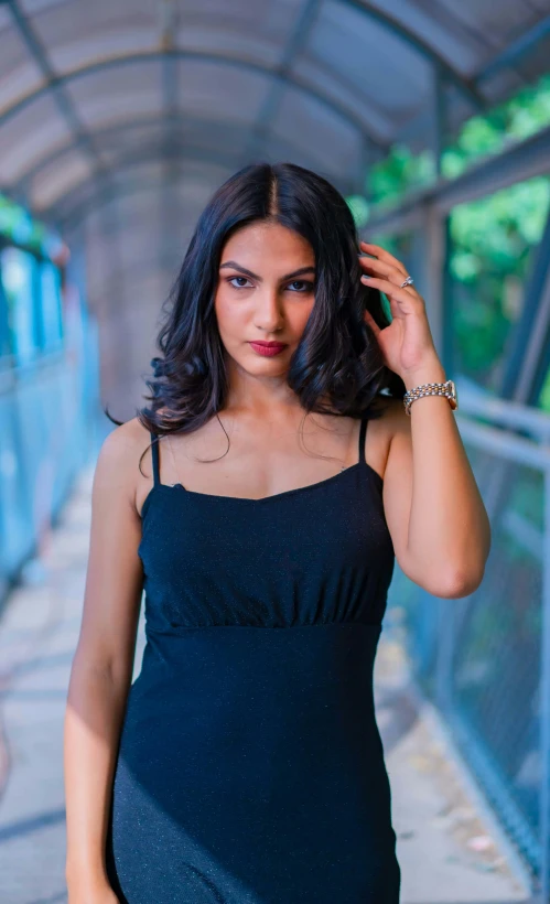 a woman in black dress leaning up against a wall