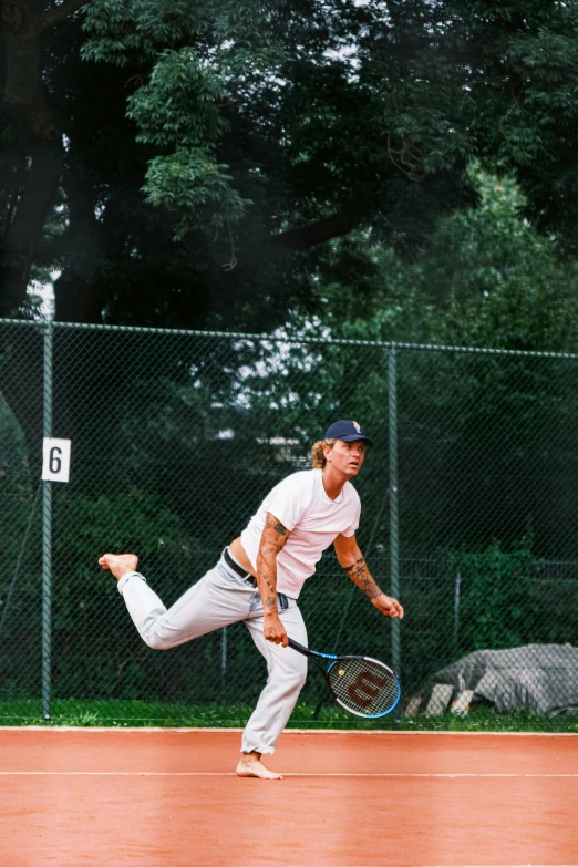 a man running on one leg with a tennis racket in his other hand