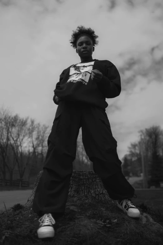 an afro man posing in front of a tree