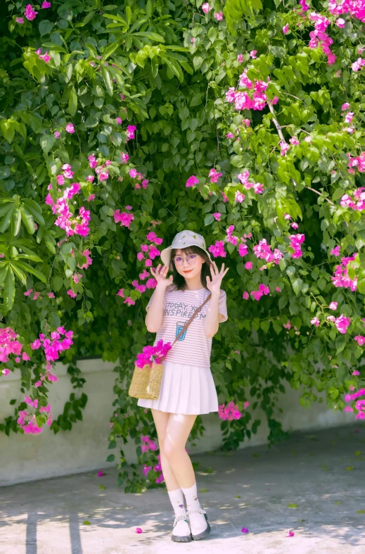 a girl is making the peace sign in front of flowering trees