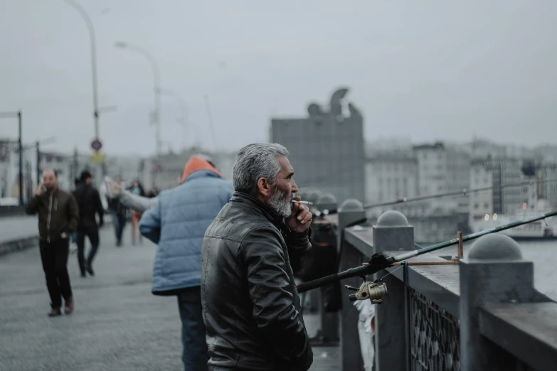 a man is on the sidewalk while holding his fishing rod