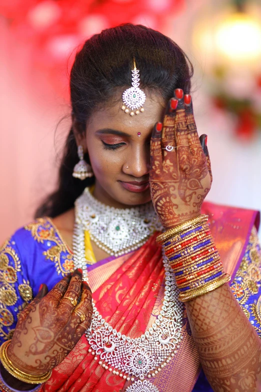 a bride in a purple and yellow outfit holding her hands together