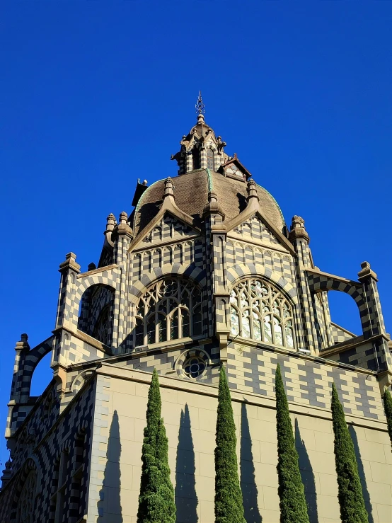 a tall building has lots of windows and trees on the side