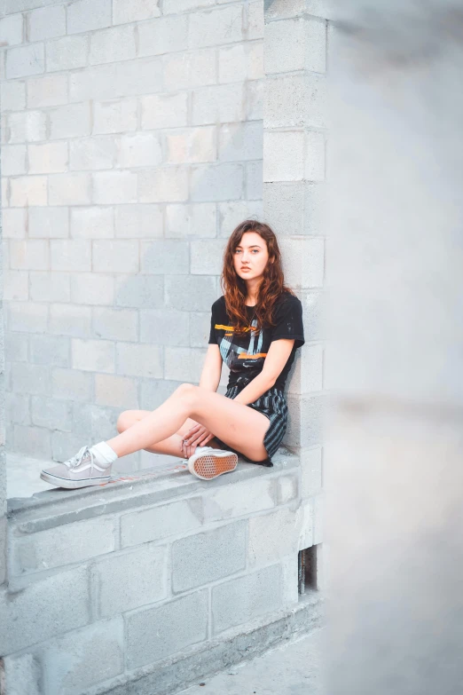 a woman is sitting on the ledge of a building with shoes