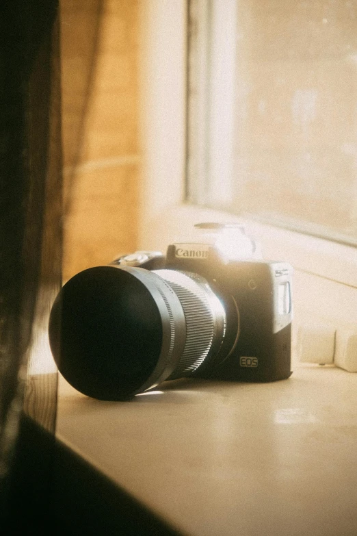 a camera laying on a counter in front of a window