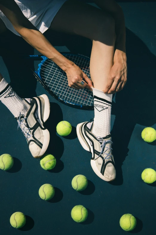 two people are playing tennis with balls on the ground