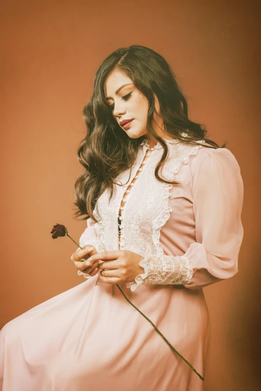 a woman with long black hair and a white dress is holding a rose