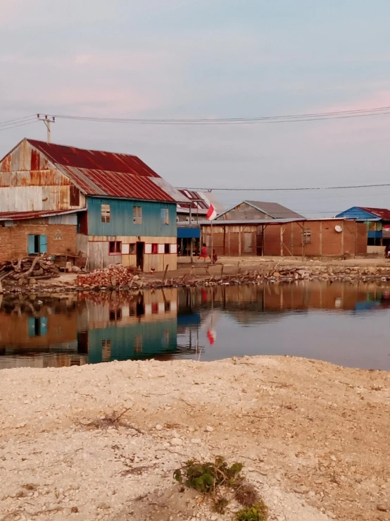 several houses with metal roofs near water