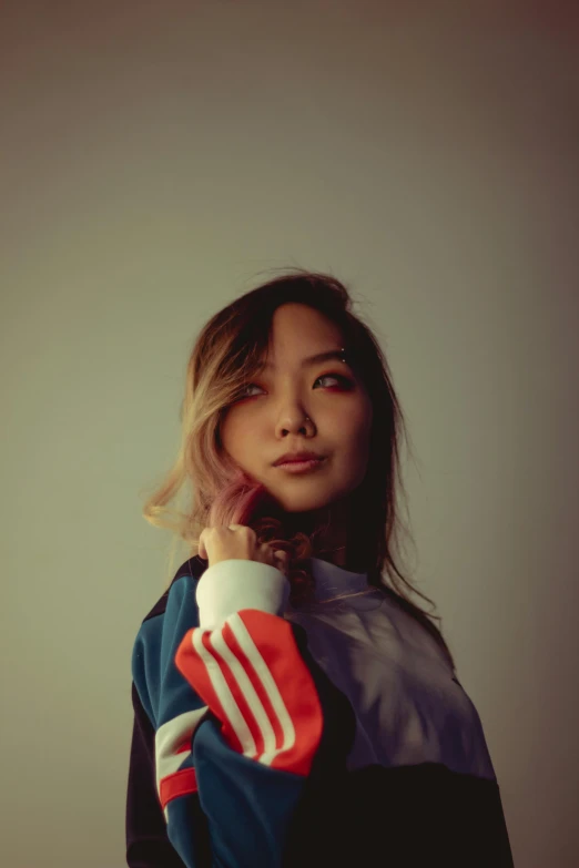 a young woman wearing a red, white, and blue baseball jacket