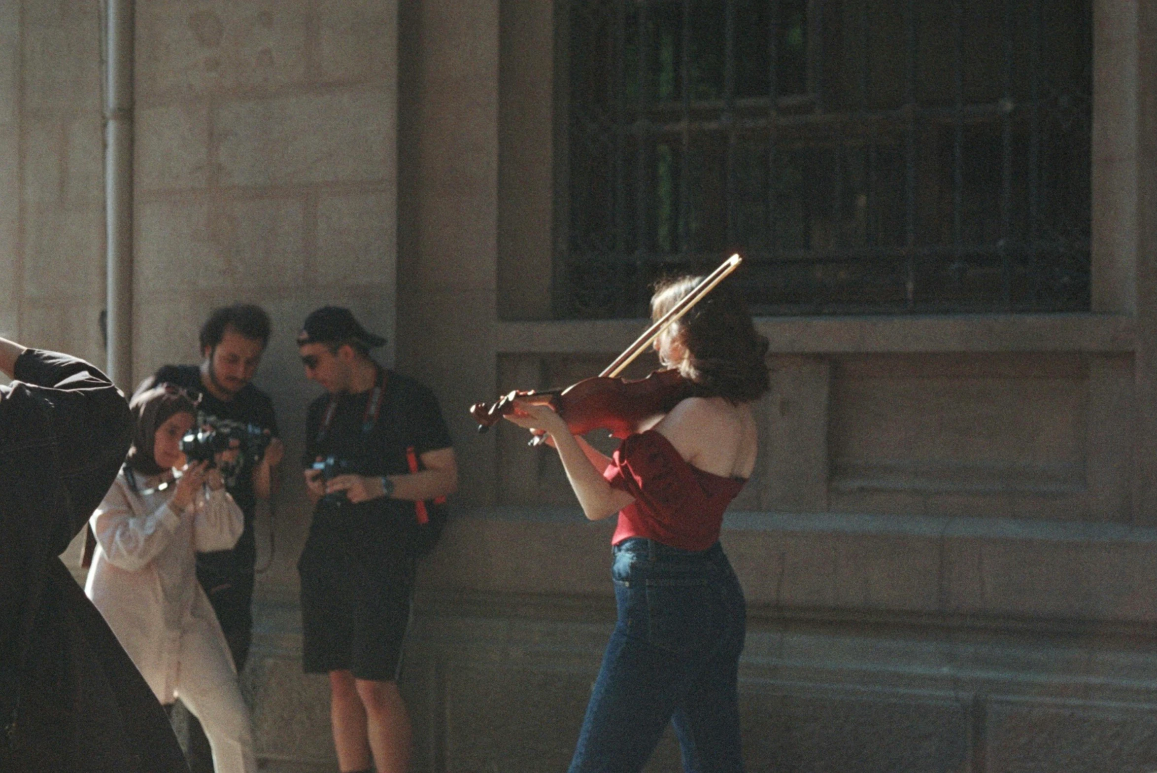 the woman is playing violin as the group of people take pictures