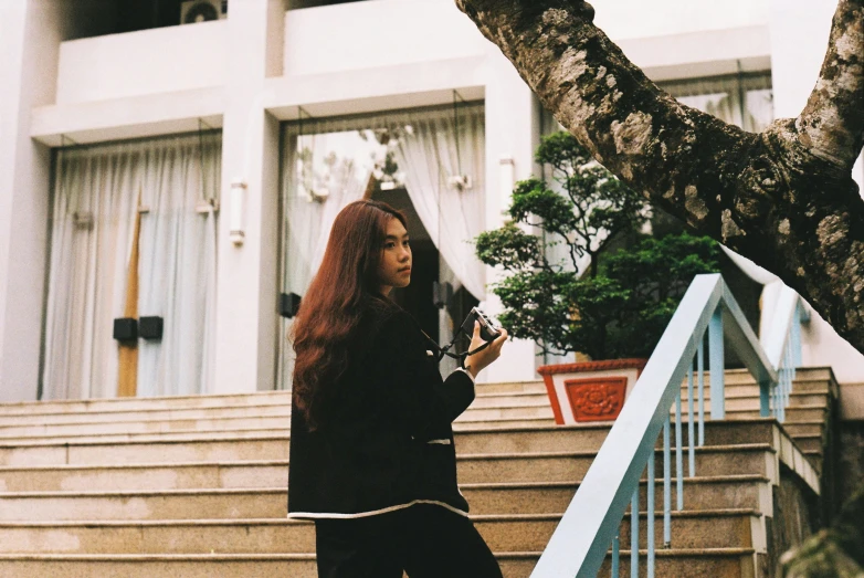 a woman is walking down the stairs in front of a house