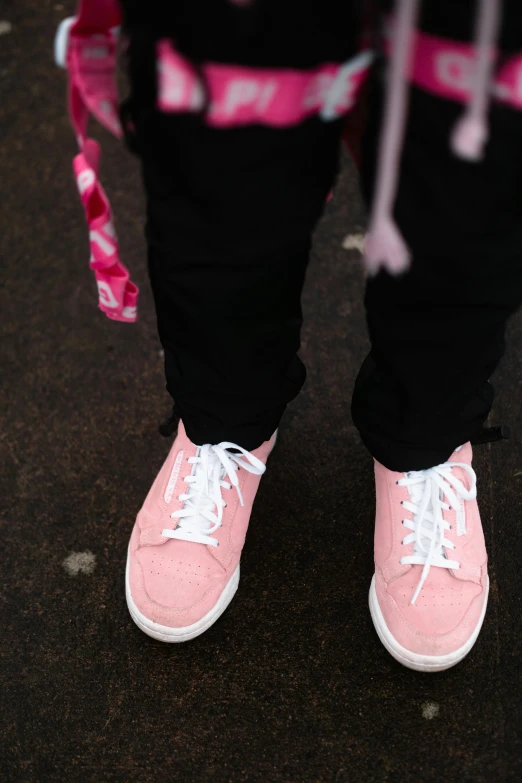 a pink tennis shoe with white laces on it