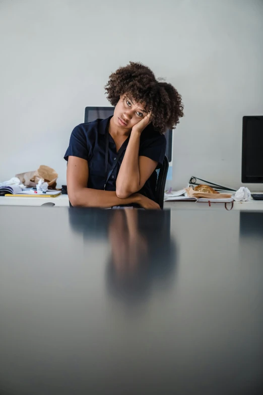 a woman sitting in an office chair behind a desk