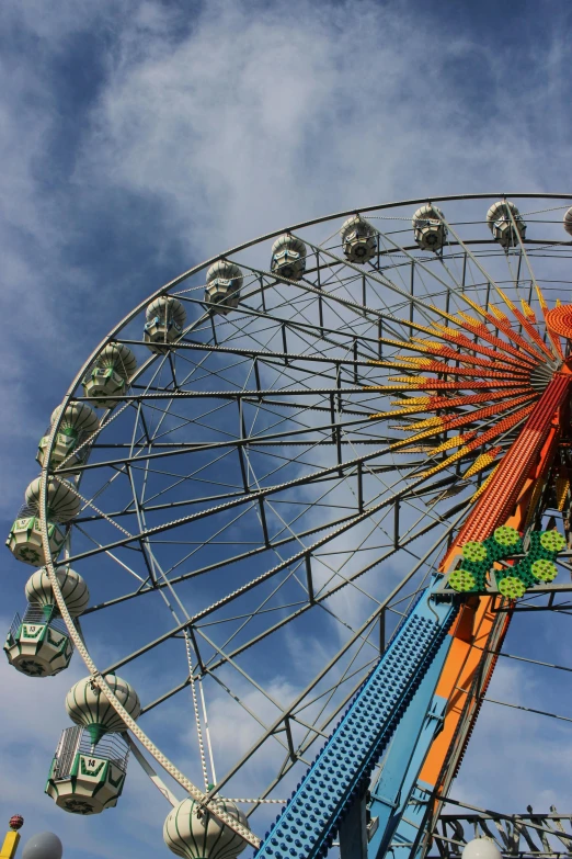 a ferris wheel on a fair against a cloudy blue sky