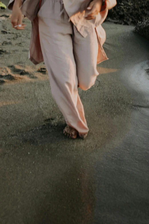 person with brown shirt and pink pants walking on beach