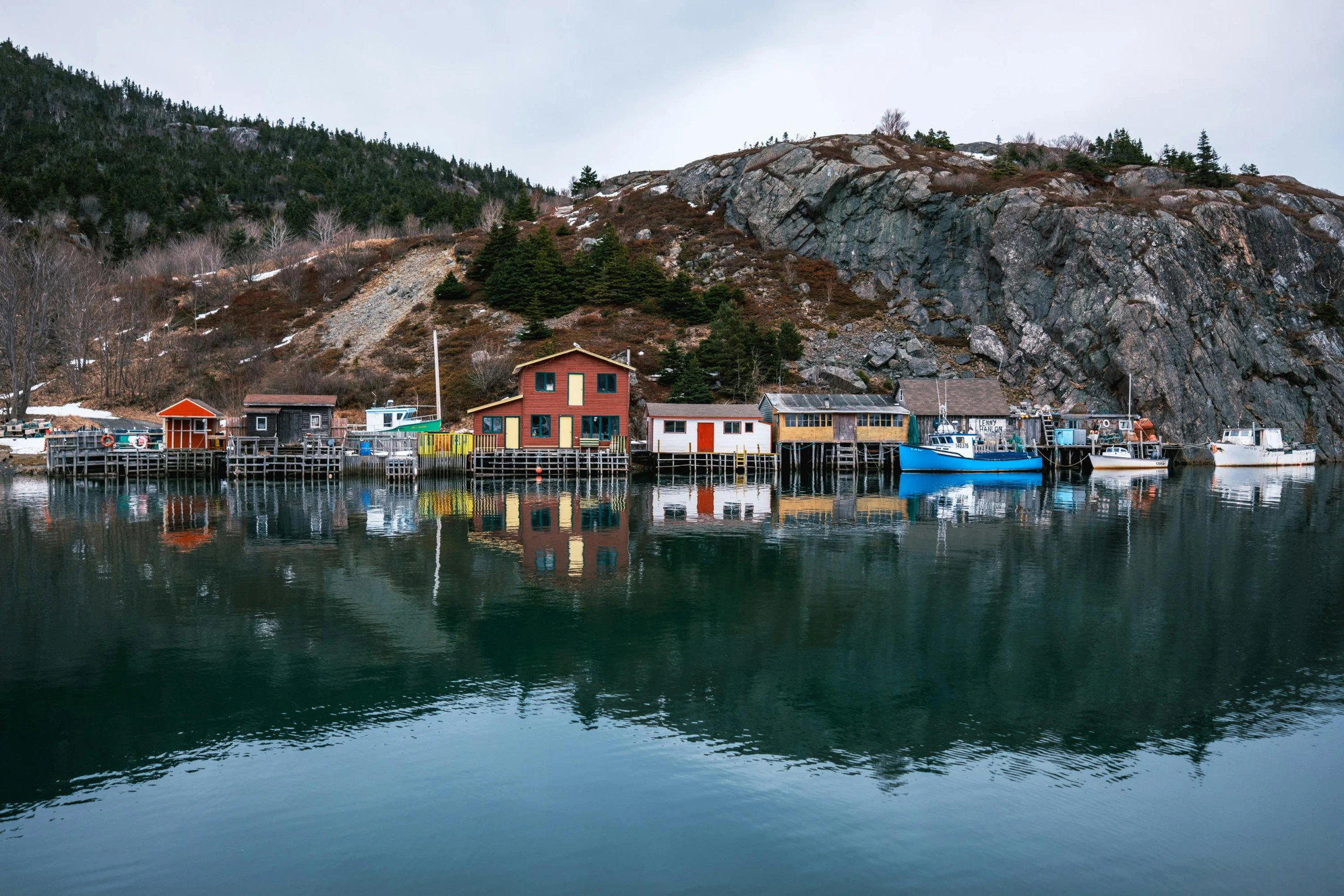 a lake with boats in it near a small hill