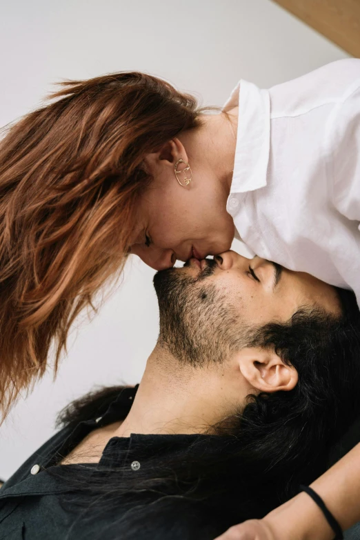 an asian man kissing the forehead of his girlfriend