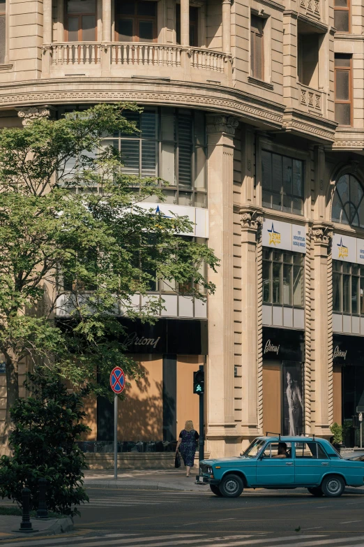 a blue vintage car sitting in front of a building