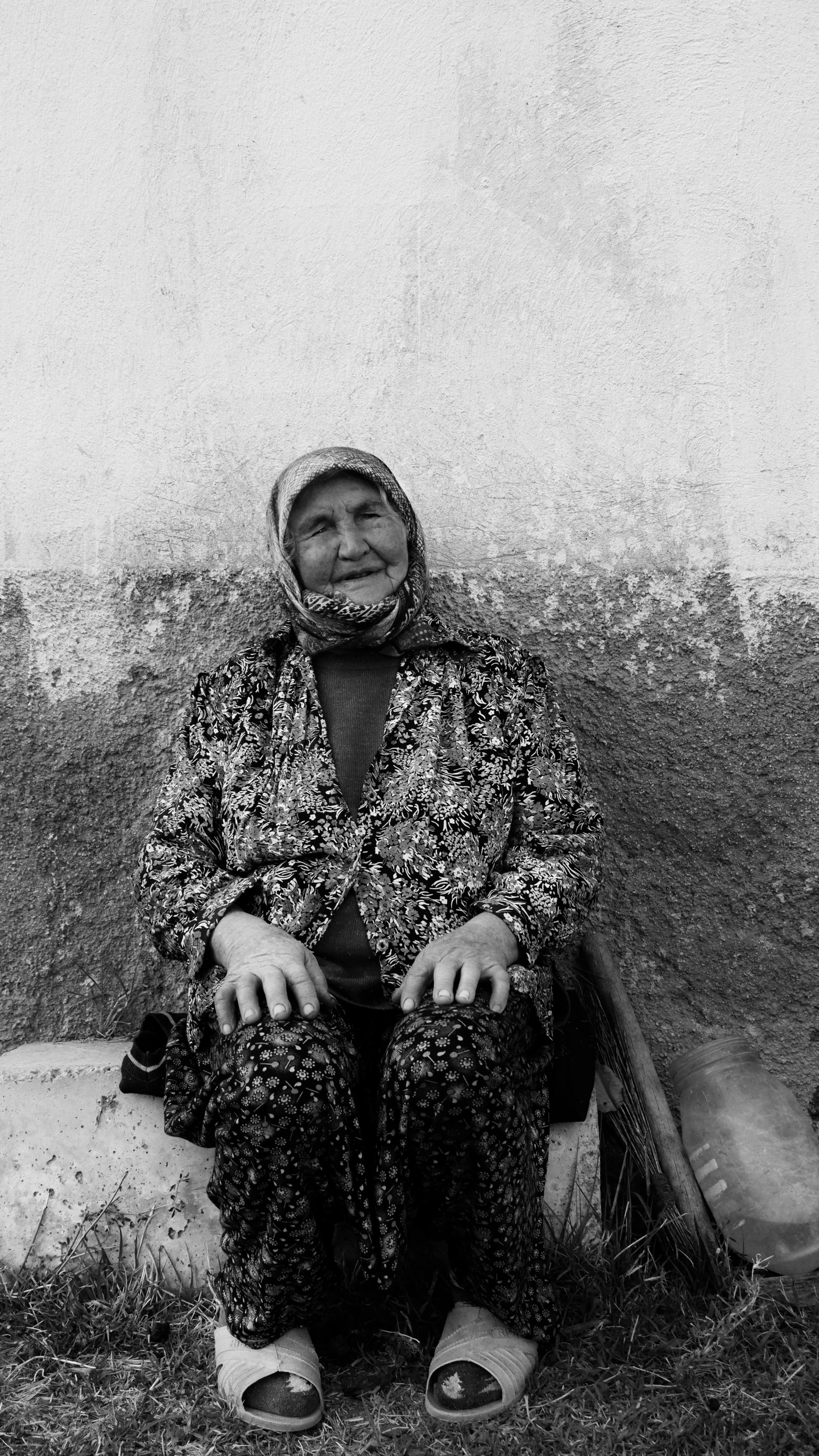 a woman sitting on a fire hydrant in front of a wall