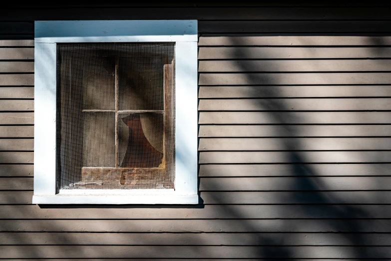 a small window in a wood shingled house