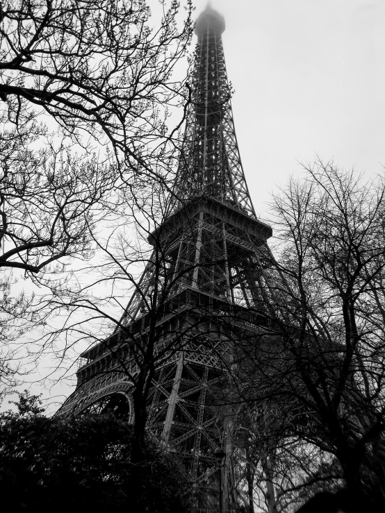 a large tower with a tall top sitting next to a tree